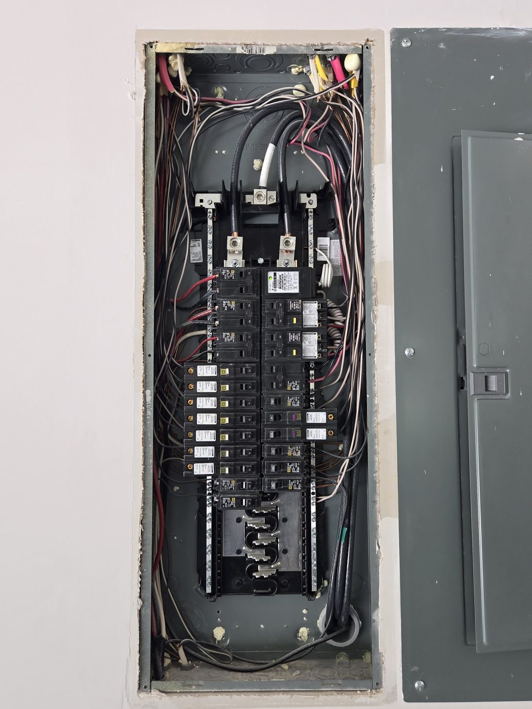Open residential electrical panel showing breakers and wiring