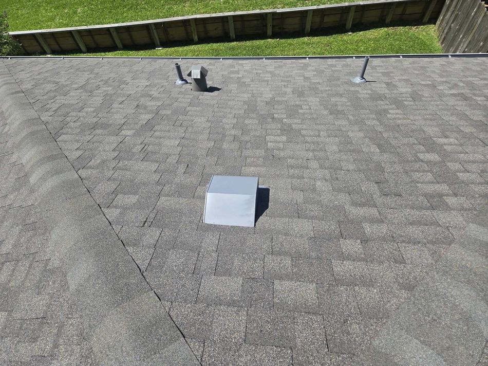 Asphalt shingle roof with plumbing vents and a metal attic vent