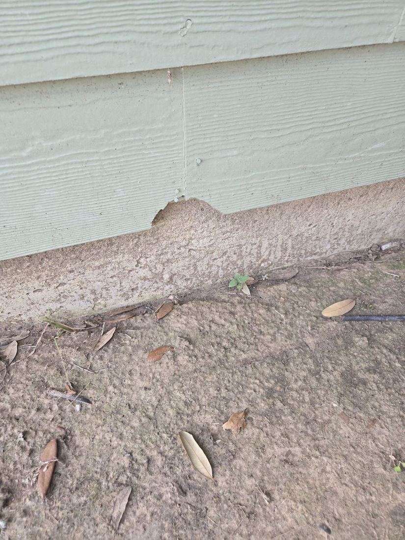 Gap between light green siding and bare soil at the base of a wall during a Tomball, Texas home inspection